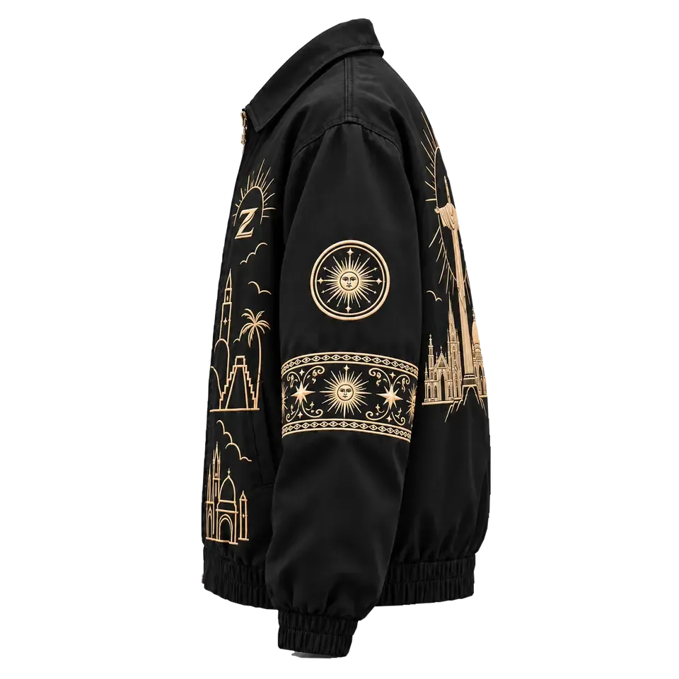 One Culture Jacket, side: black sleeve with an embroidered sun medallion and a band of stars in tonal gold thread